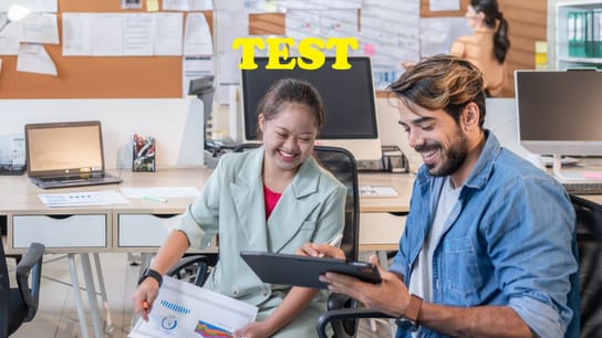 Young businesswoman with Down Syndrome working with her colleague in an office