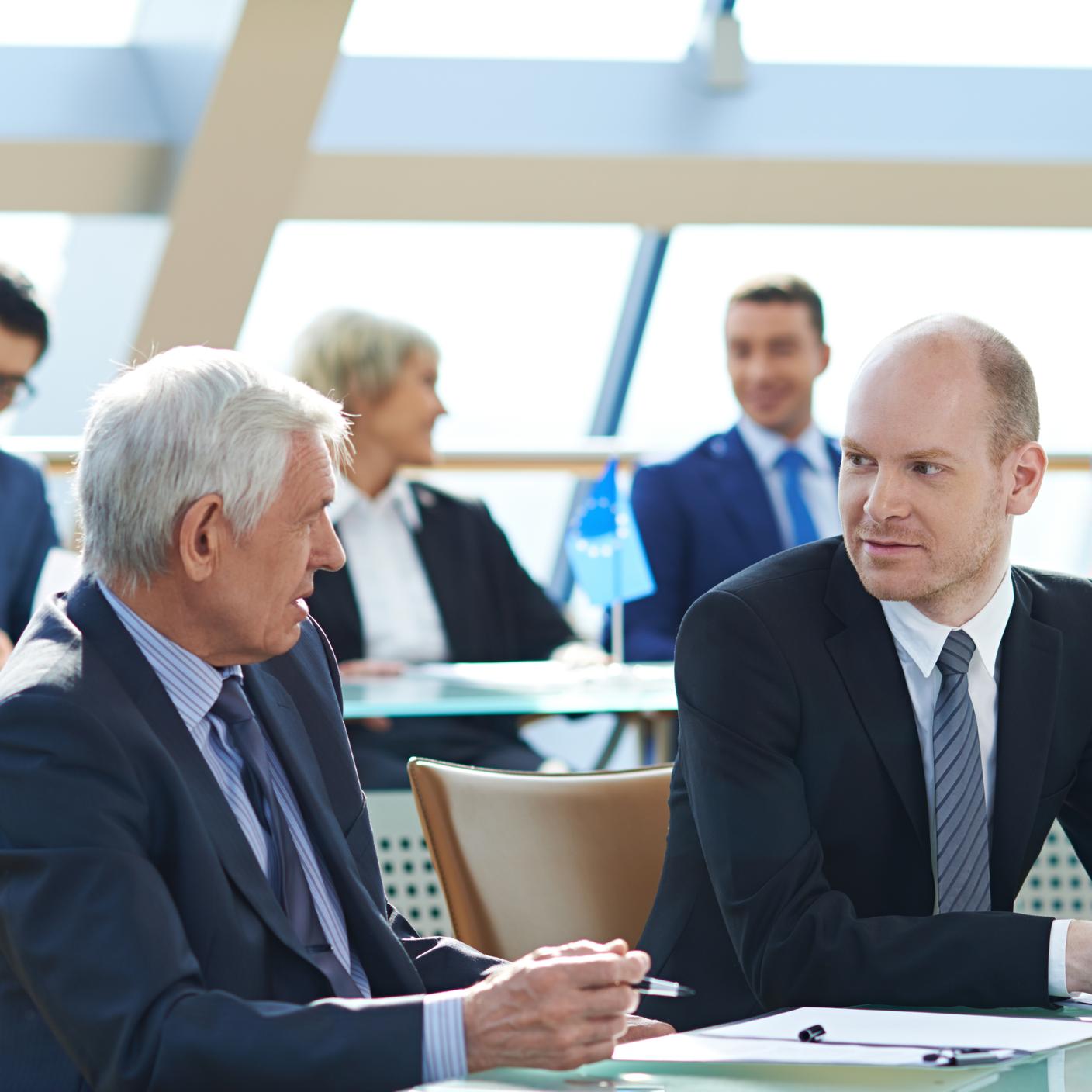 Multiple people discussing at meeting.