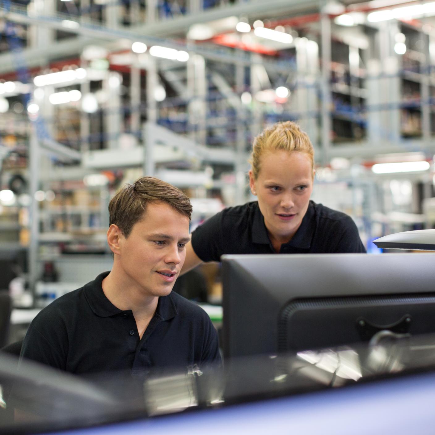 Mitarbeitende, die einen Computer im Logistiklager benutzen