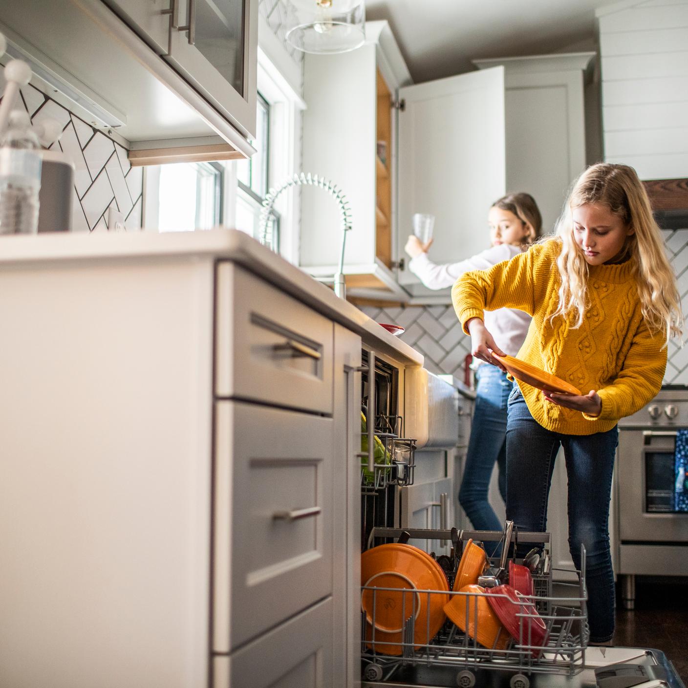 Soutenir le passage à un système à faible consommation d’énergie - Des préadolescentes font la vaisselle dans la cuisine