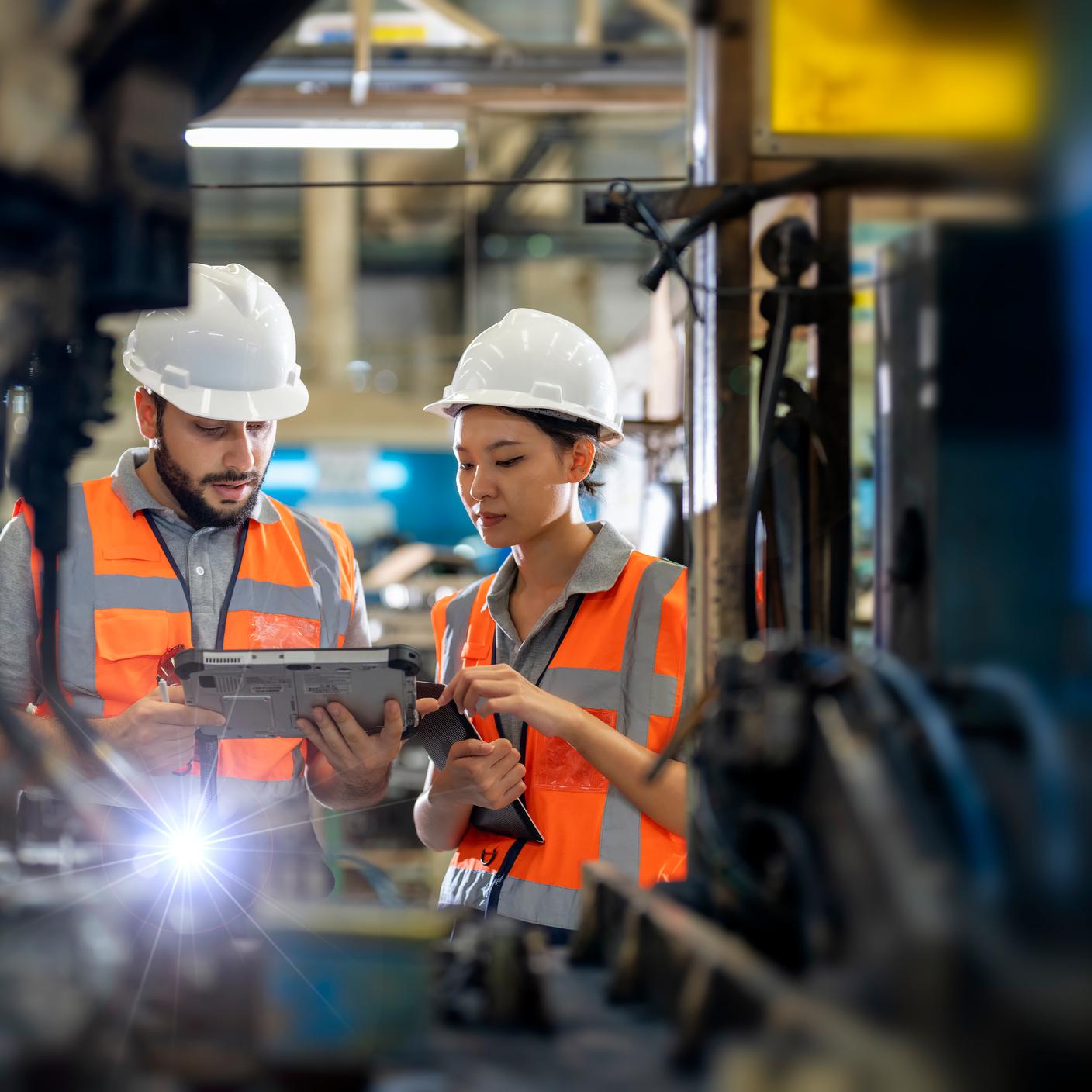 Ingenieros observando las unidades de soldadura de brazos robóticos en funcionamiento en la fábrica. Mejore la productividad de la fabricación y el concepto de control de calidad. Automatización de procesos robóticos para la industria de fabricación de autopartes.