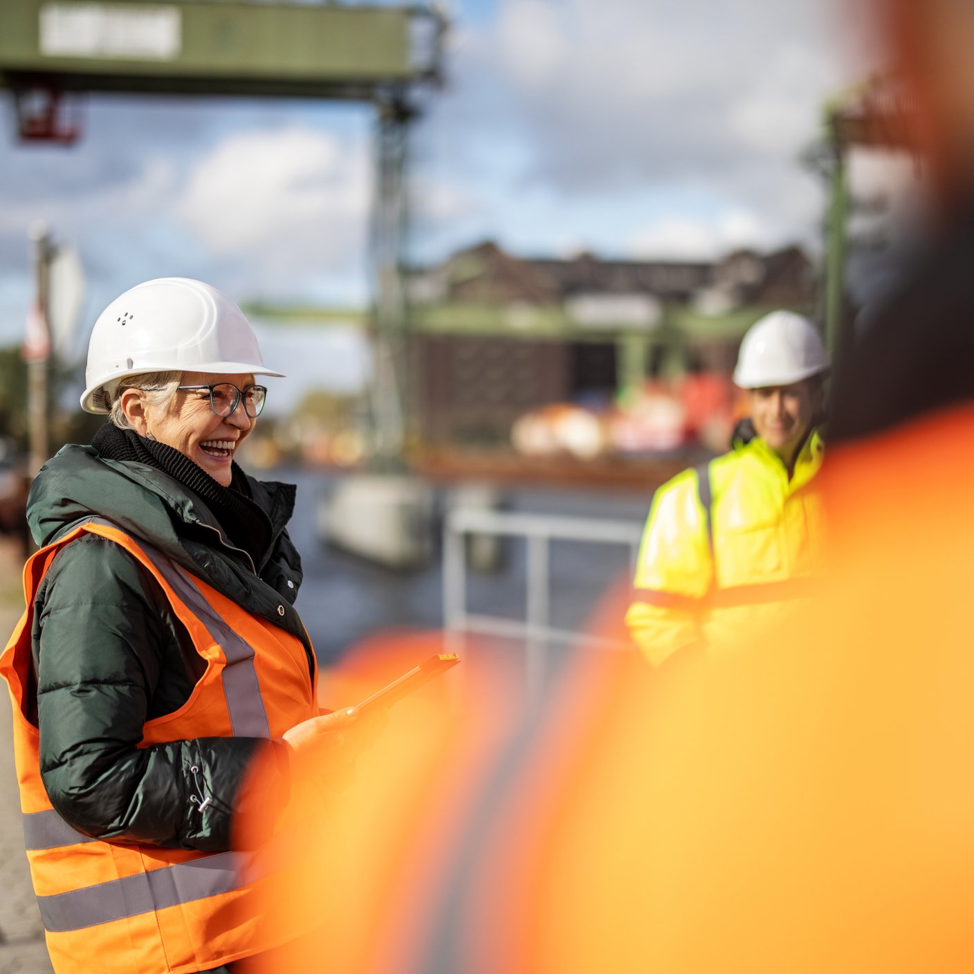 Senior woman manager smiling during meeting with team at large commercial dock