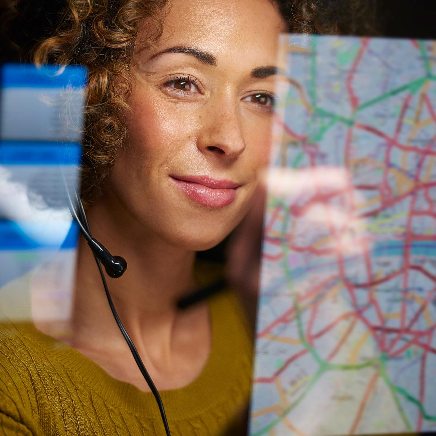 Une travailleuse du secteur de la logistique organise l’expédition du fret sur sa carte numérique interactive tout en parlant dans son casque.