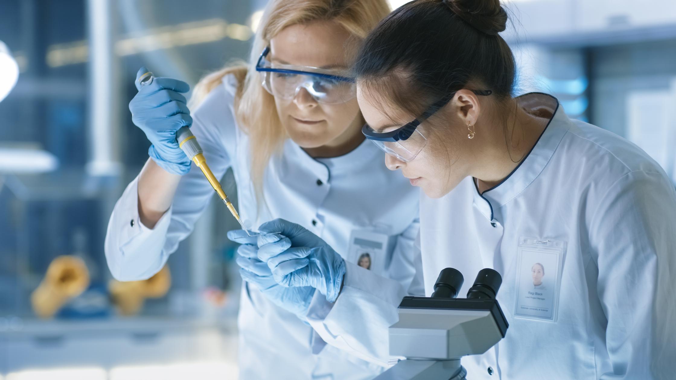 Two workers in a laboratory using medical devices