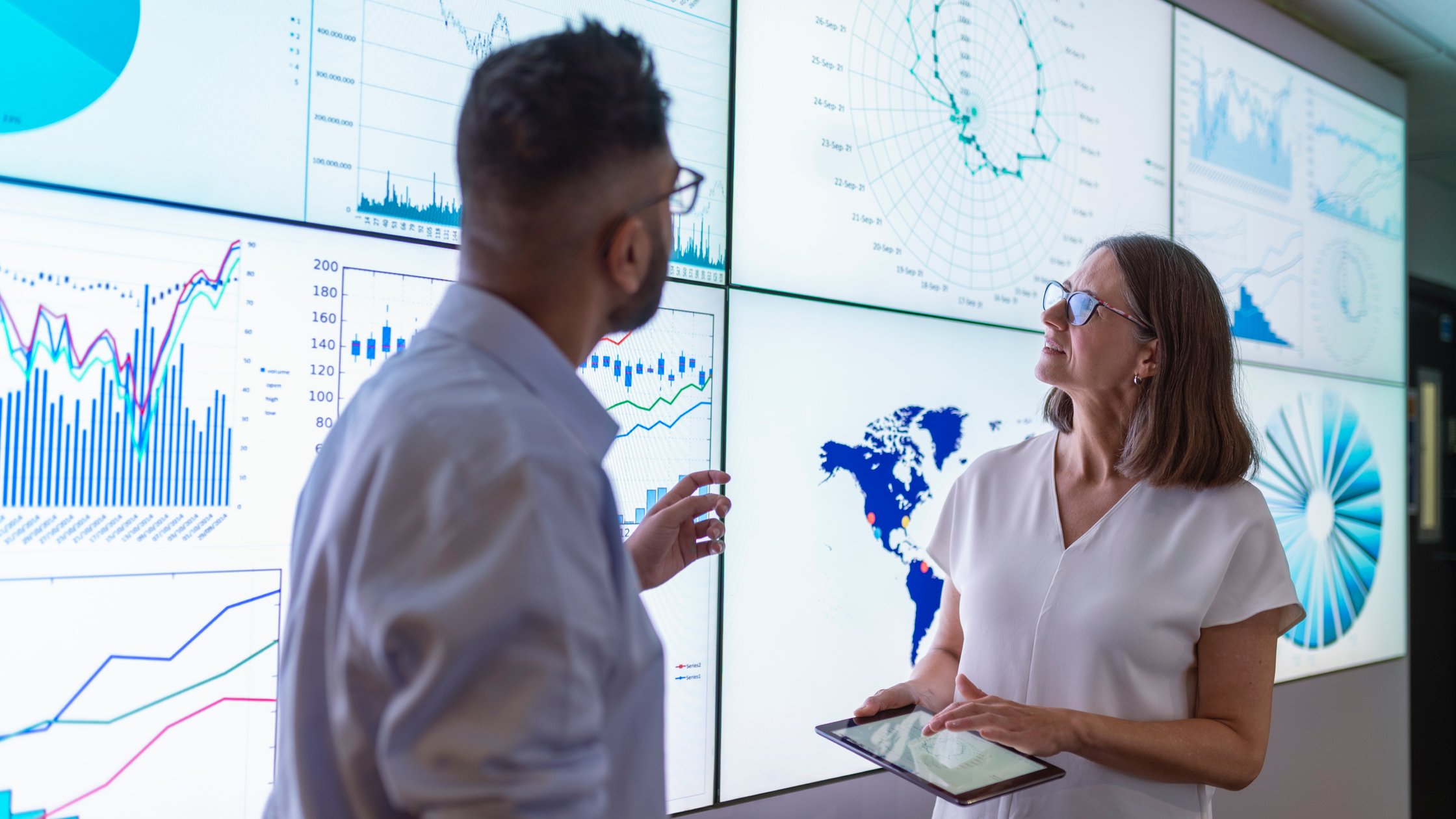 UK, York, Business people discussing charts on interactive screens